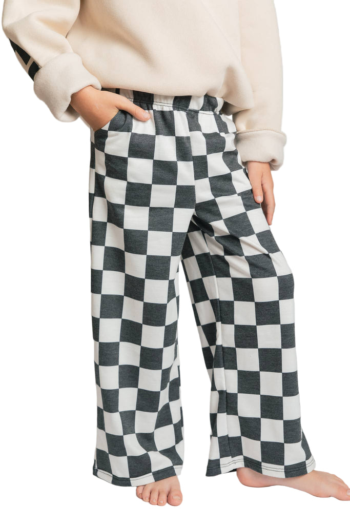 Person wearing black and white checkered pants on a plain background
