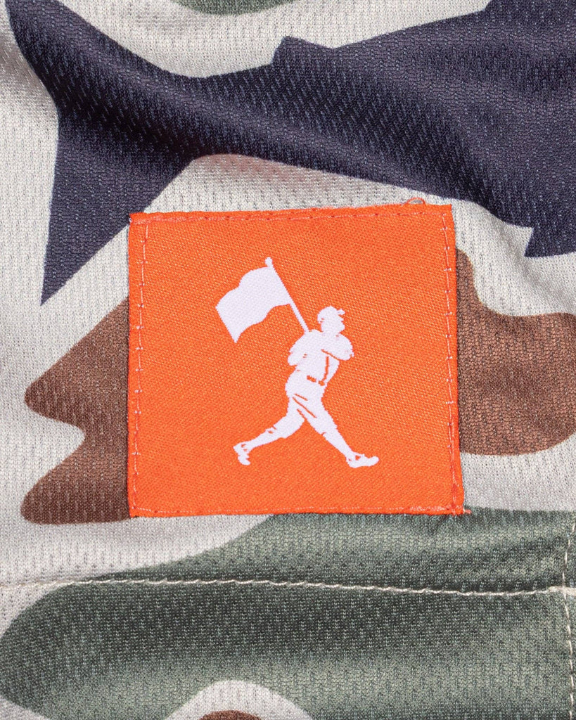 Orange patch with white graphic on a camouflage background