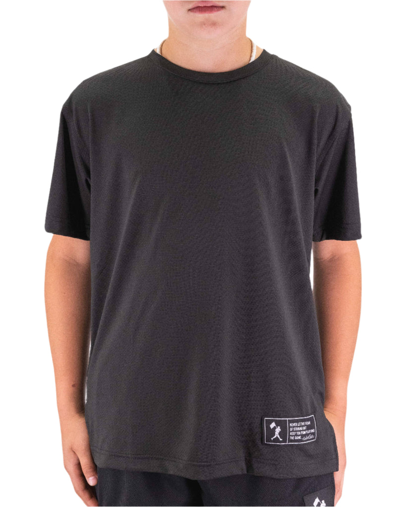 Person wearing a black t-shirt with a small logo on a plain background
