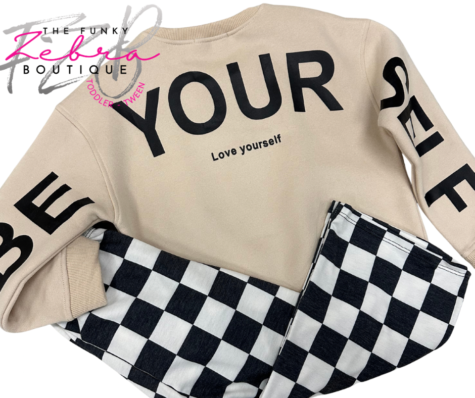 Beige sweatshirt with 'Be Yourself' text and checkered pants on a white background, featuring 'The Funky Zebra Boutique' logo.