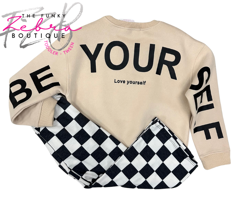 Beige sweatshirt with text and checkered pants, branded 'The Funky Zebra Boutique'.