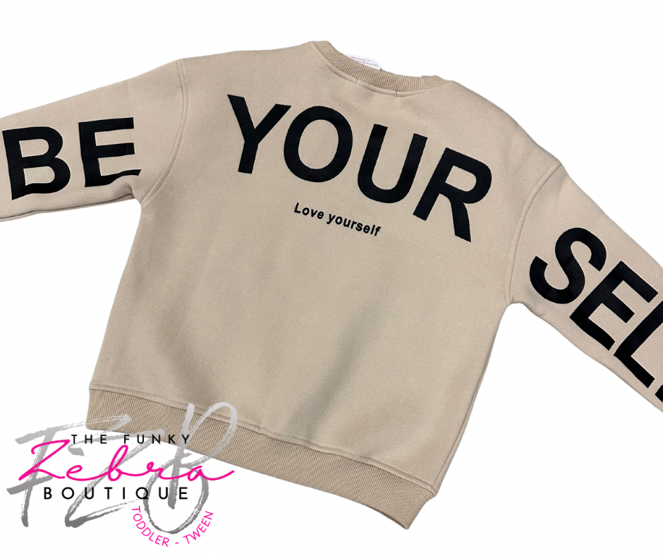 Beige sweatshirt with 'BE YOURSELF' text on a white background, featuring The Funky Zebra Boutique logo.