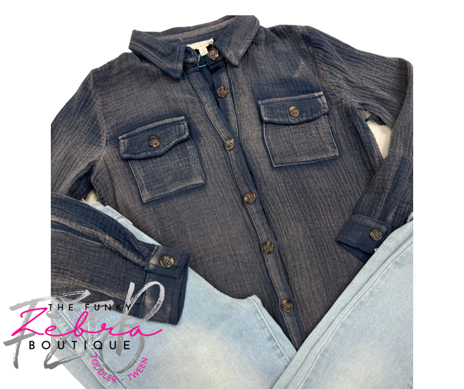 Blue denim shirt with button details on a white background, featuring 'The Funky Zebra Boutique' logo.