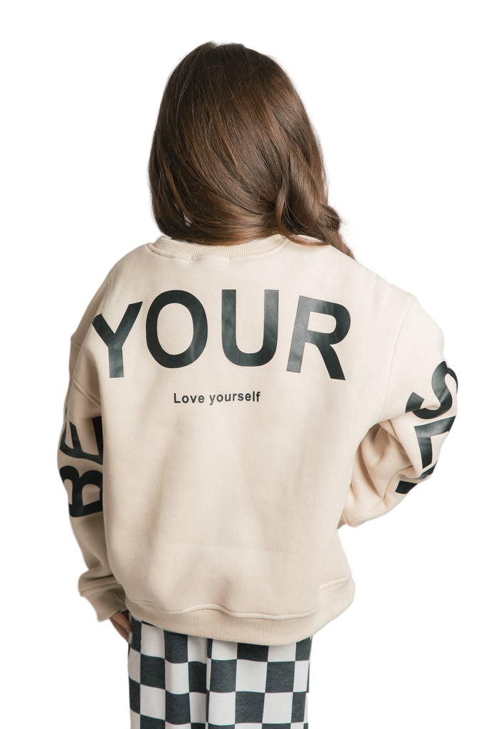 Person wearing a beige sweatshirt with 'YOUR' and 'Love yourself' text on a plain background